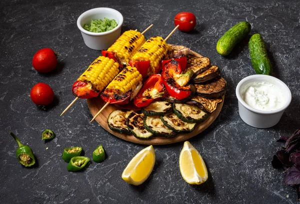 Koyu taş arka plan üzerinde çeşitli lezzetli ızgara sebzeler. Yaz barbekü.