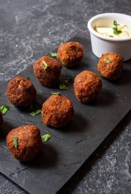 fresh vegetarian falafel balls with sauce on stone background clipart