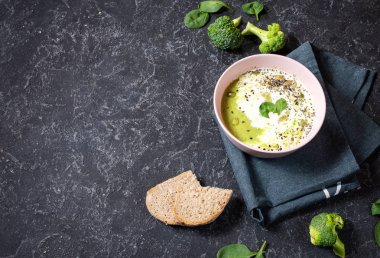 Brokoli kreması çorbası ve siyah taş masa üzerinde malzemeler