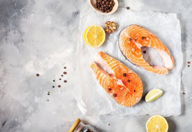 İki taze çiğ somon bifteği, tuz, biber ve çimento kaplı limon..