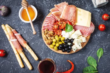 İtalyan antipasto, jambon, peynir, zeytin ve siyah taş arka planda Grissini ekmeği. Üst görünüm