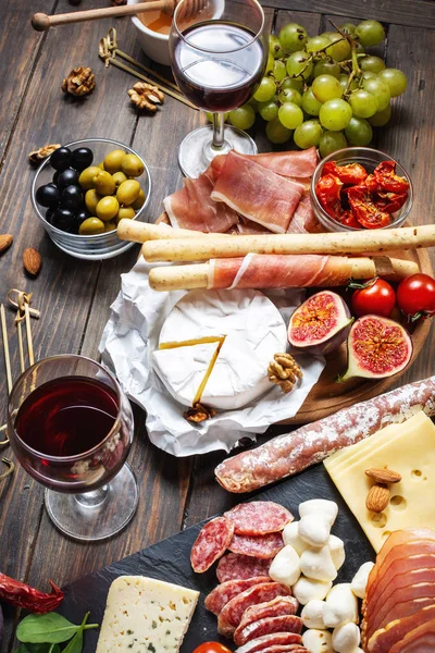 Italienische Antipasti mit Prosciutto, Schinken, Käse, Oliven und Grissini-Brot auf Holzboden — Stockfoto
