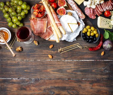 İtalyan antipasto, jambon, peynir, zeytin ve kırsal ahşap arka planda Grissini ekmeği. Üst görünüm