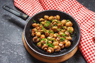 Siyah taş masada tavada lezzetli kızarmış mantarlar