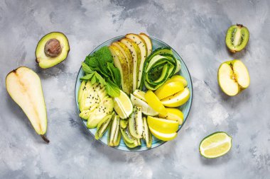 Avokado, kivi, elma, salatalık, armut, limon ve naneli taze salata. Sağlıklı yemek, Buda kasesi, üst manzara.