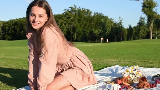 Ung Smilende Kvinde Slapper Udendørs Har Picnic Tæppe Græsset – Stock-video