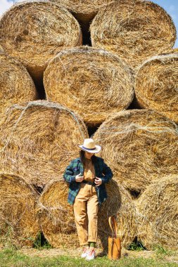 Samanlıkta tulumlu ve şapkalı genç bir kadın. Kırsalda tarlada kadın portresi.