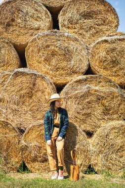 Samanlıkta tulumlu ve şapkalı genç bir kadın. Kırsalda tarlada kadın portresi.