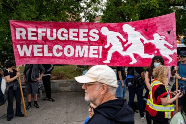 Mülteciler Kanada 'daki göçmen yanlısı mitingde pankartı karşılıyorlar. Toronto, Kanada - 13 Eylül 2025.