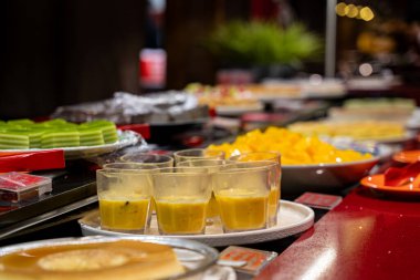 Büfe masasındaki çeşitli tatlıları ve puding bardaklarını kapat..