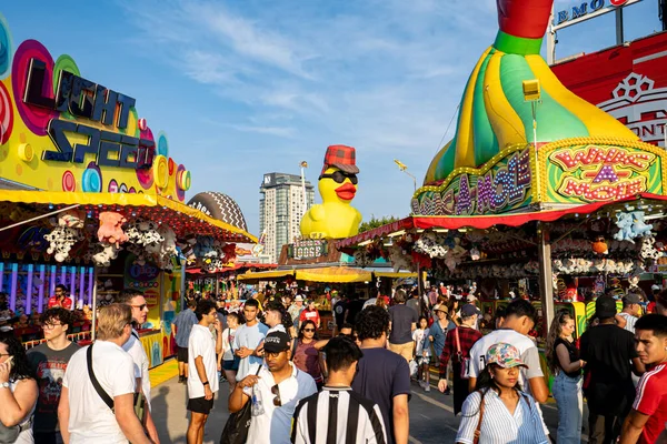 Kanada Ulusal Sergisi CNE 'de kalabalık ve doldurulmuş oyuncak ödülleriyle karnaval oyun standı manzarası. Toronto, Kanada - 16 Ağustos 2025.