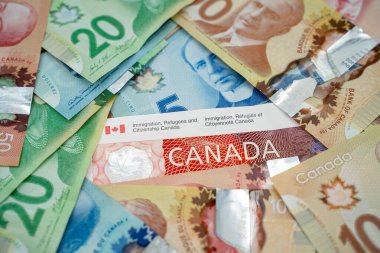 Kanada göçmenlik belgelerini dolar banknotlarıyla kapatın. Toronto, Kanada - 18 Eylül 2025.