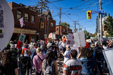 Toronto 'daki Çizgi İnsanları Barış ve Gezegen Mitingi' nde protesto işaretleri tutan kalabalığın görüntüsü. Toronto, Kanada - 20 Eylül 2025.