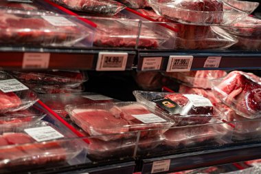 Süpermarket raflarında sergilenen paketlenmiş çiğ biftekleri kapat.