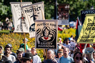Protesto işareti gösteride çimenlerin daralması için adaleti gösteriyor. Toronto, Kanada - 20 Eylül 2025.