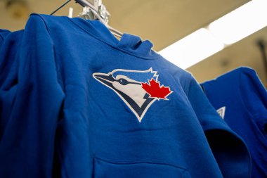 Mavi Toronto Blue Jays kapüşonlusu ve takım logosu mağazada asılı. Toronto, Kanada - 24 Eylül 2025.