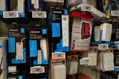 Hırdavatçı raflarında çeşitli güç çubukları ve gerilim koruyucuları sergileniyor. Toronto, Kanada - 24 Eylül 2025.