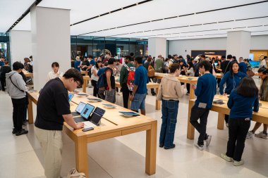 Kalabalık Apple Mağazası 'nın içi müşterilerle dolu. Ürünleri keşfediyorlar. Toronto, Kanada - 24 Eylül 2025.