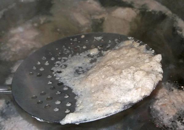 Remove the foam from boiling meat — Stock Photo, Image