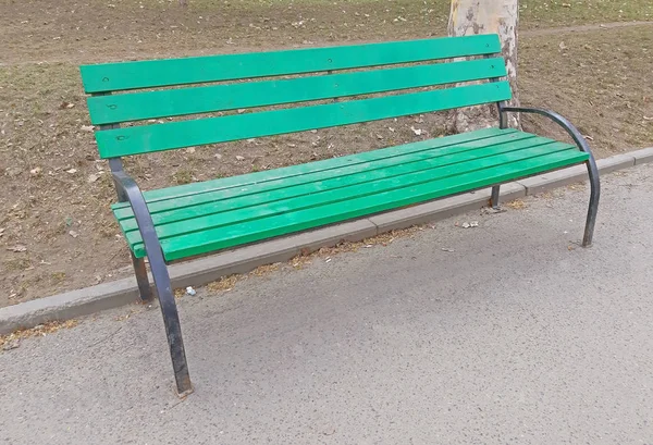 Ein grüner Stuhl im Park auf dem Bürgersteig — Stockfoto