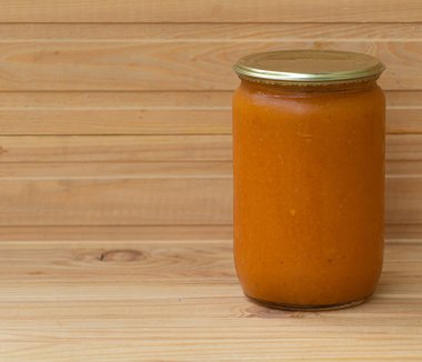 Woden arka planda kayısı reçeli ile ev yapımı bir kavanoz