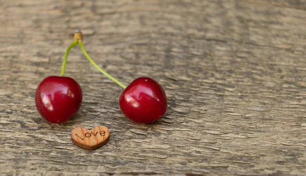 Love sweet cherries concept. Cherries on a wooden background