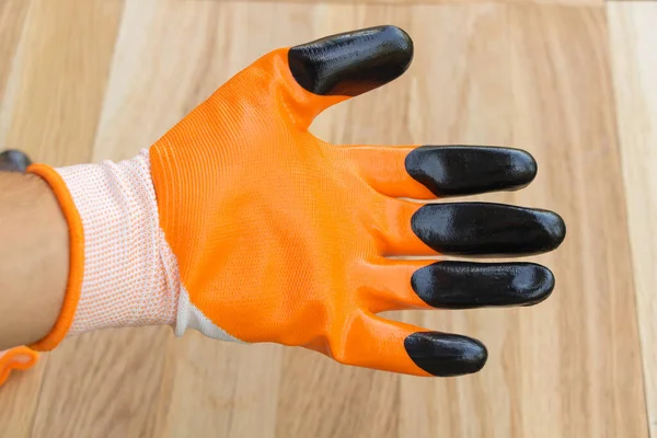 Оранжевая Строительная Перчатка Руке Деревянный Фон — стоковое фото