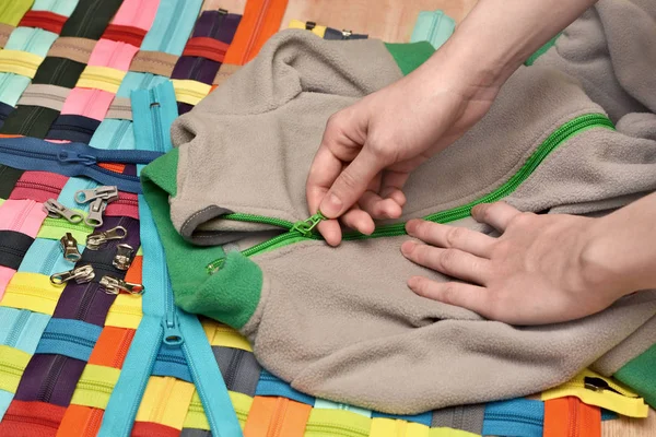 Zipper on children's things. Clothing repair. Checking the quality of fasteners on textile products