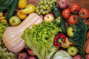 Ahşap meşe masasında çeşitli taze sebzeler ve meyveler. 