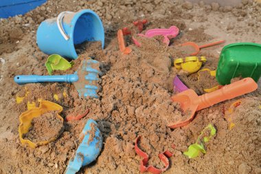 Oyun için çeşitli oyuncaklarla dolu çocuk kum havuzu. Nehir kumu