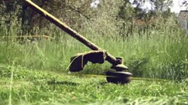 Arka bahçede çim biçme makinesi ve çim biçme makinesiyle çim biçme makinesi. 4K video.