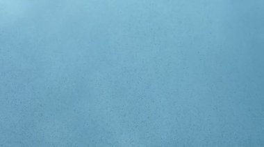 Soyut parçacıklar mavi suda hareket eder. Denize düşen kum kavramı. Yavaş çekim.