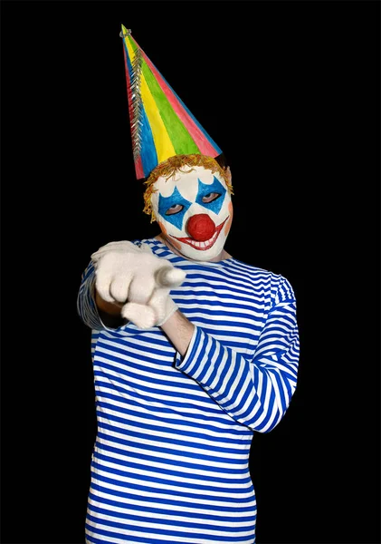 Человек Маске Клоуна Праздничной Кепке Указывает Указательным Пальцем Камеру Изолированный — стоковое фото