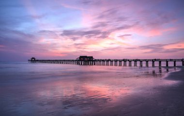 Pink and purple sunset over the Naples Pier clipart