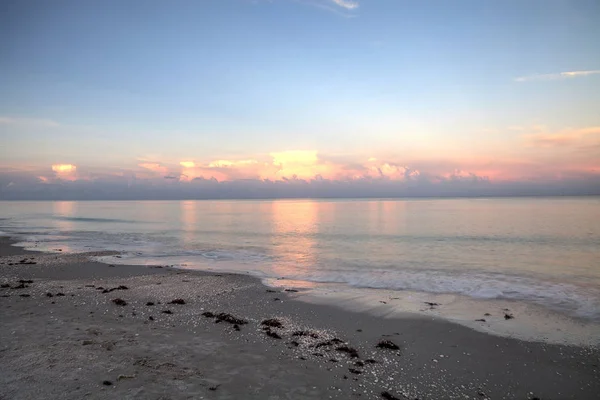 Pink sky over a calm ocean in Naples, Florida along the Gulf Coast