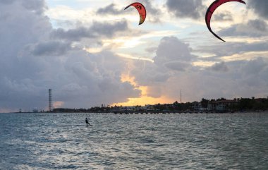 Gün batımında Güney Florida Sahili boyunca okyanusta bir uçurtma sörfçü silüeti.