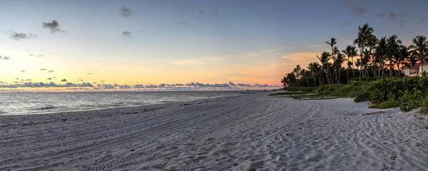 Dilapidated ruins of a pier on Port Royal Beach at sunset in Naples, Florida