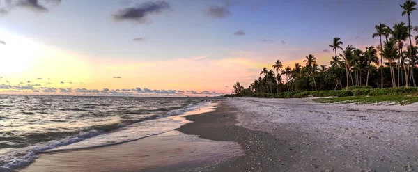 Dilapidated ruins of a pier on Port Royal Beach at sunset in Naples, Florida