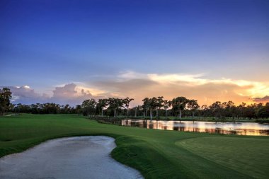 Altın göl günbatımı kum tuzağına yakınındaki tropik bir adada bir golf sahasında.