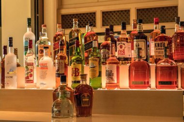 Naples, Florida, ABD - 3 Kasım 2018: Seçim renkli içki alkol şişeleri satırının arka aydınlatma ile bir bar raf. Editoryal kullanım.
