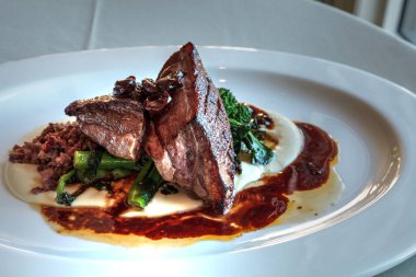 Gurme Ahududu soslu ördek brokoli ve mantar yemek tabağı üzerinde kavrulmuş.