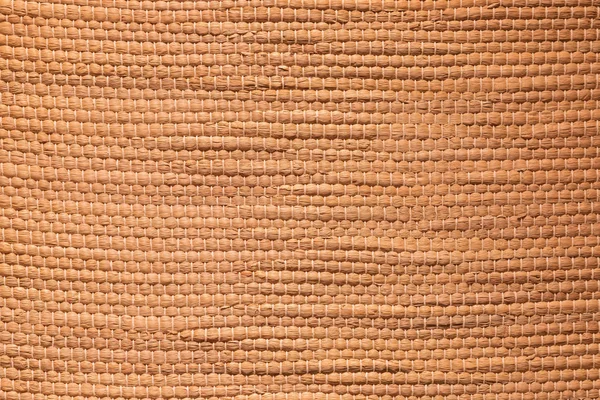 Tan textured bamboo fabric background tied together in knots.