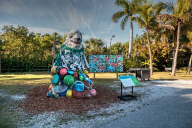 Naples, Florida, USA - December 23, 2018: Lidia the Seal Sculpture made of garbage found in the ocean as part of the Washed Ashore art exhibit and environmental movement showcased at the Naples Zoo. clipart