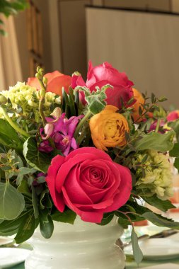 Buket kırmızı gül, mor orkide, portakal, gül ve Yeşiller de dahil olmak üzere.