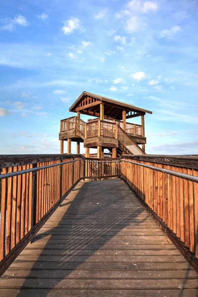 Torre de observación de aves al final de un paseo marítimo al amanecer en T — Foto de Stock