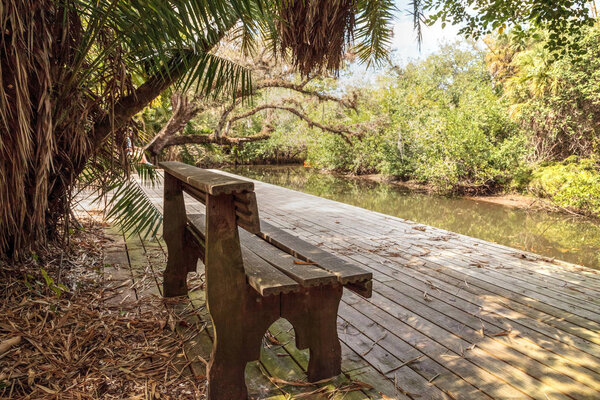 Old dock and bench along the riverway at historic Koreshan State