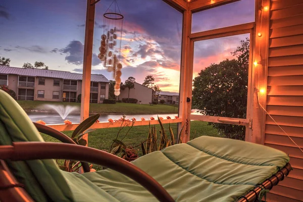 Swingende lounge stoel op een lanai bij zonsondergang als het kijkt uit over een pon — Stockfoto