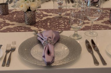 Bir leylak renkli peçete, beyaz gül ile mor yer ayarı