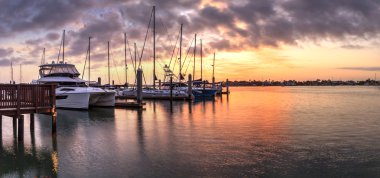 Break of dawn sunrise over boats and sailboats at Factory Bay ma clipart