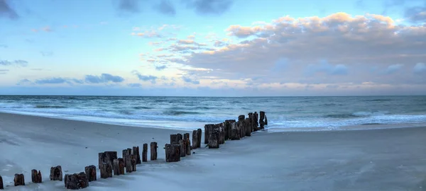 Dawn over a dilapidated pier on the beach in Port Royal